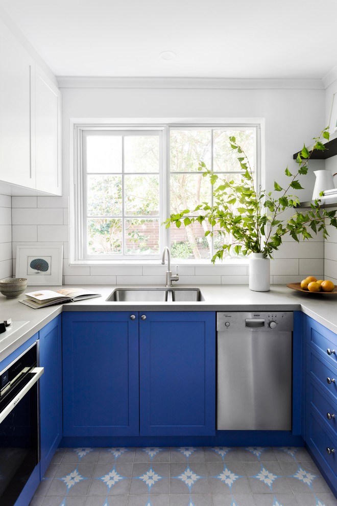 Small contemporary u-shaped separate kitchen in Melbourne with blue cabinets, quartz benchtops, white splashback, ceramic splashback, stainless steel appliances, cement tiles, grey benchtop, an undermount sink, shaker cabinets and grey floor.