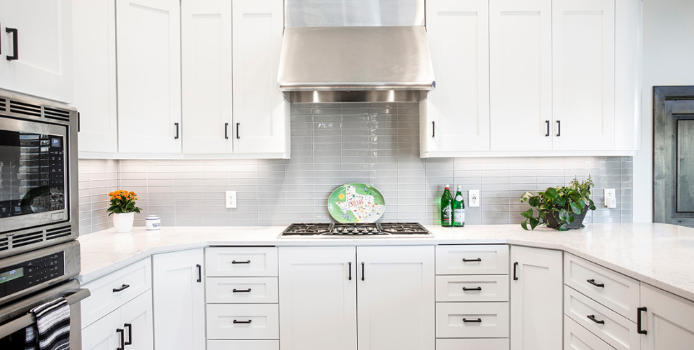 Idee per una cucina abitabile design di medie dimensioni con ante bianche, top in marmo, paraspruzzi grigio, paraspruzzi con piastrelle di vetro, elettrodomestici in acciaio inossidabile e top bianco