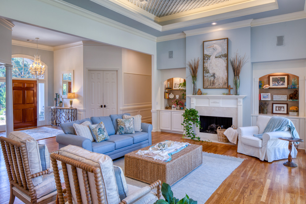 Идея дизайна: открытая гостиная комната в морском стиле с синими стенами, паркетным полом среднего тона, стандартным камином, коричневым полом, многоуровневым потолком и потолком с обоями
