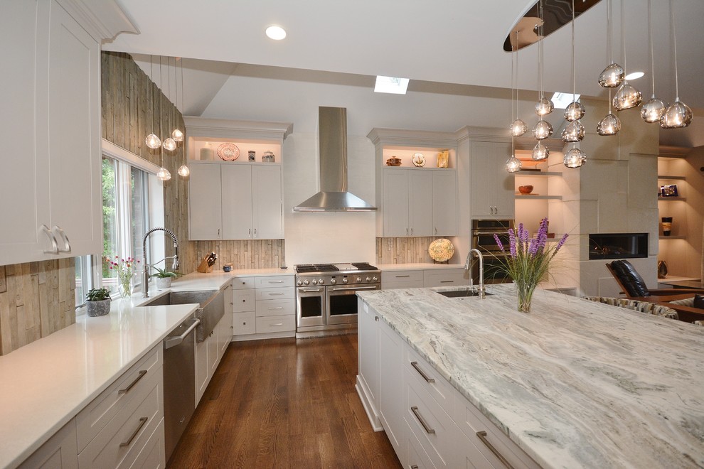 Inspiration for a large transitional u-shaped eat-in kitchen in Other with a farmhouse sink, recessed-panel cabinets, white cabinets, limestone benchtops, beige splashback, porcelain splashback, stainless steel appliances, dark hardwood floors, with island, brown floor and grey benchtop.