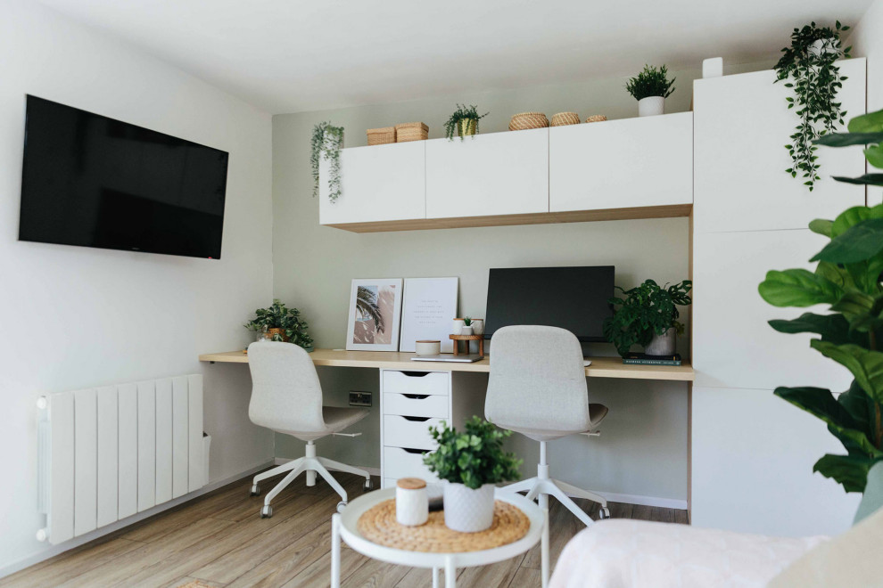 На фото: большой кабинет в скандинавском стиле с белыми стенами, светлым паркетным полом, встроенным рабочим столом и бежевым полом с