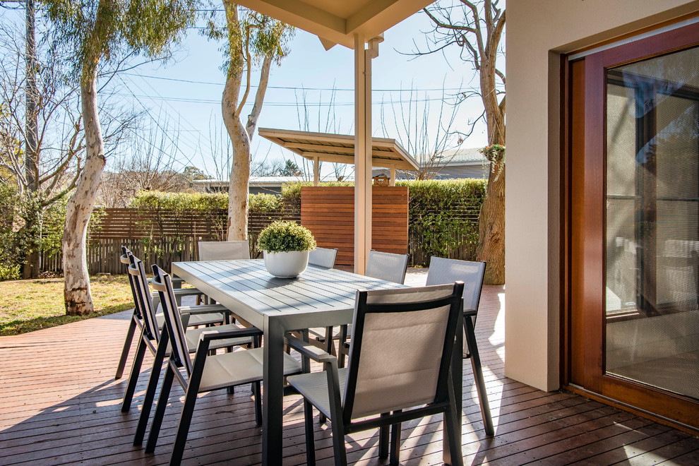 Photo of a contemporary backyard deck in Canberra - Queanbeyan with a pergola.