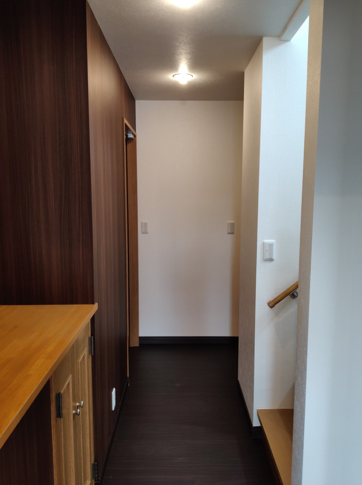 This is an example of a mid-sized modern hallway in Other with beige walls, vinyl floors, black floor, wallpaper and wallpaper.