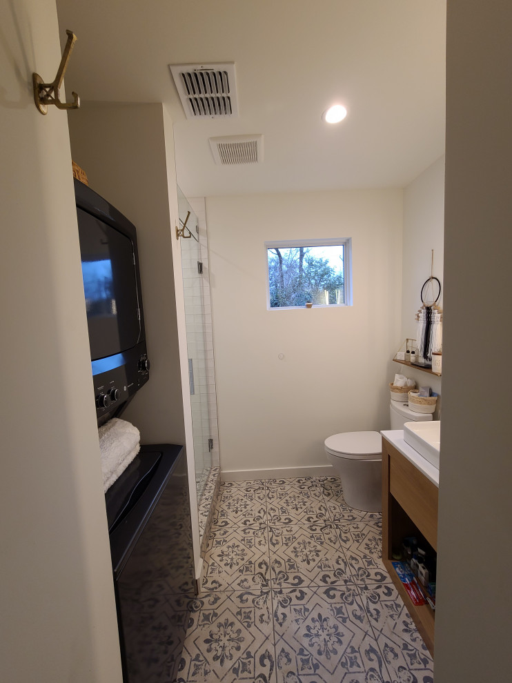 Photo of a small midcentury master bathroom in Dallas with flat-panel cabinets, light wood cabinets, an alcove shower, a one-piece toilet, white walls, ceramic floors, a vessel sink, engineered quartz benchtops, beige floor, a hinged shower door, white benchtops, a laundry, a single vanity and a built-in vanity.