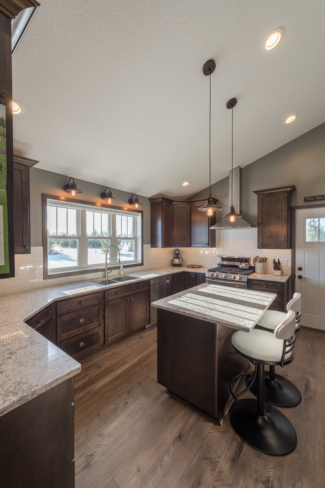 Inspiration for a large rustic u-shaped dark wood floor and brown floor enclosed kitchen remodel in Minneapolis with a double-bowl sink, shaker cabinets, dark wood cabinets, granite countertops, white backsplash, subway tile backsplash, stainless steel appliances and an island