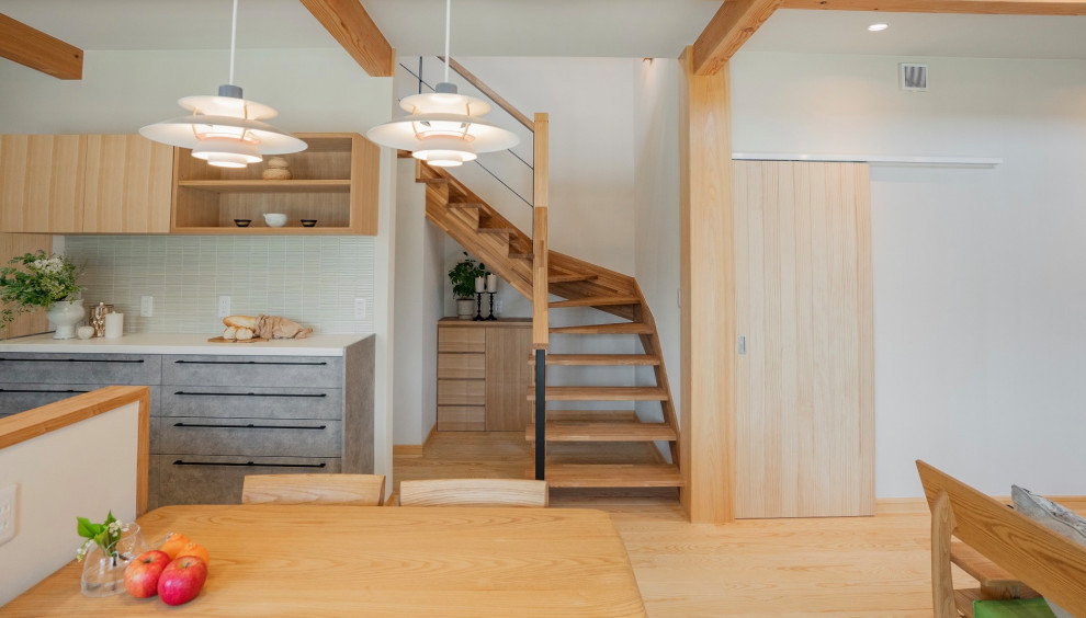 This is an example of a scandinavian wood l-shaped staircase in Other with open risers and mixed railing.