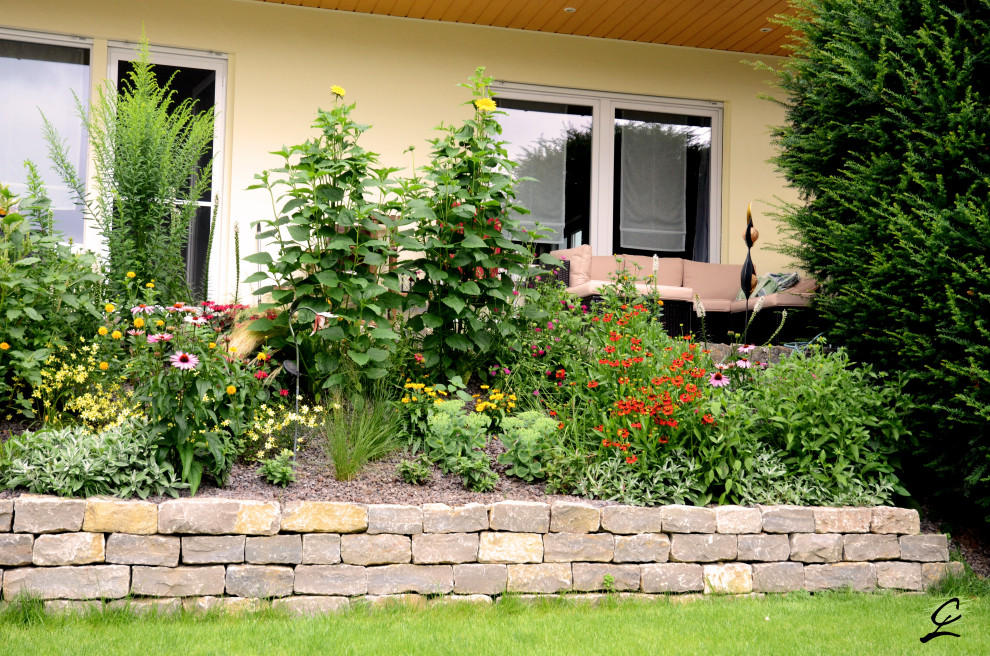 Design ideas for a mid-sized traditional partial sun side yard stone landscaping in Frankfurt for summer.