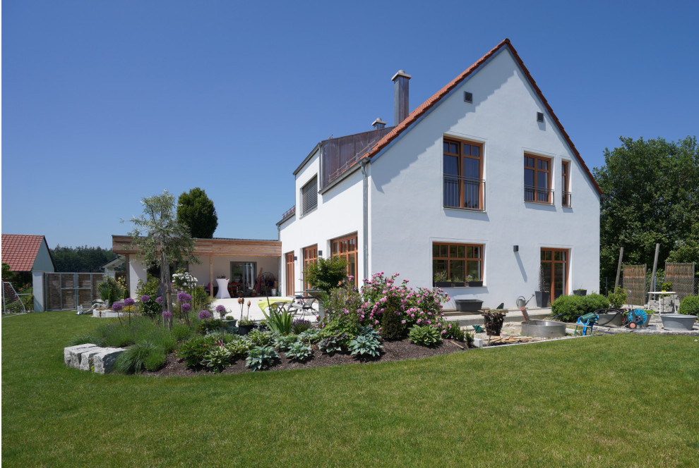 Geometrischer, Großer Country Garten im Sommer, neben dem Haus mit Blumenbeet, direkter Sonneneinstrahlung und Natursteinplatten in München