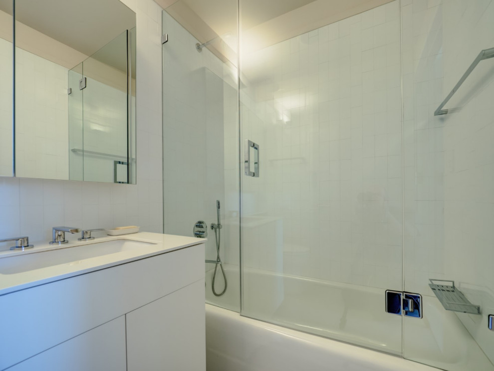 Exempel på ett mellanstort modernt vit vitt en-suite badrum, med släta luckor, vita skåp, ett badkar i en alkov, en dusch/badkar-kombination, en toalettstol med hel cisternkåpa, vit kakel, porslinskakel, vita väggar, terrazzogolv, ett undermonterad handfat, bänkskiva i kvarts, grått golv och dusch med gångjärnsdörr