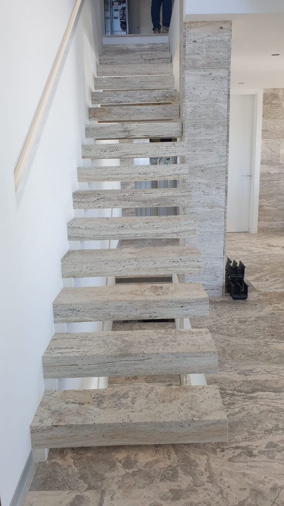 Idée de décoration pour un escalier méditerranéen avec des marches en travertin et des contremarches en travertin.