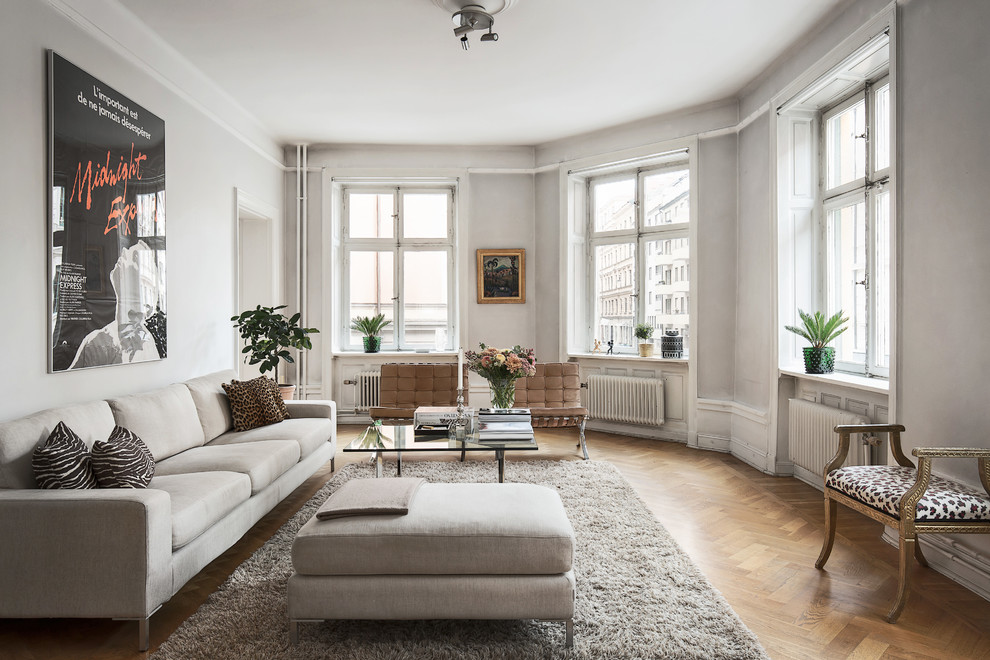 This is an example of a large scandinavian formal open concept living room in Stockholm with grey walls, no tv and medium hardwood floors.