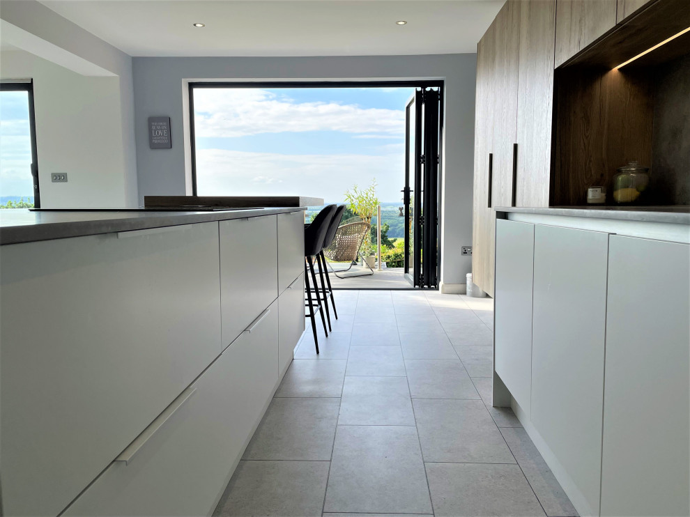 Photo of a mid-sized contemporary l-shaped eat-in kitchen in Other with a single-bowl sink, flat-panel cabinets, white cabinets, solid surface benchtops, grey splashback, vinyl floors, with island, grey floor and grey benchtop.