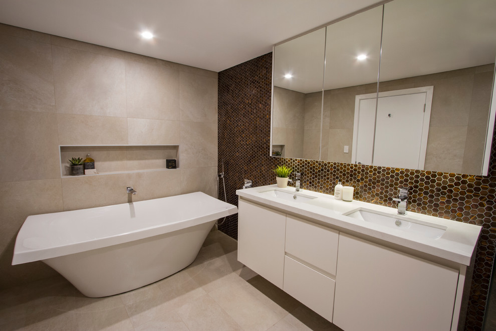 Inspiration for a large contemporary 3/4 bathroom in Sydney with flat-panel cabinets, white cabinets, mosaic tile, brown walls, ceramic floors, a drop-in sink and a freestanding tub.