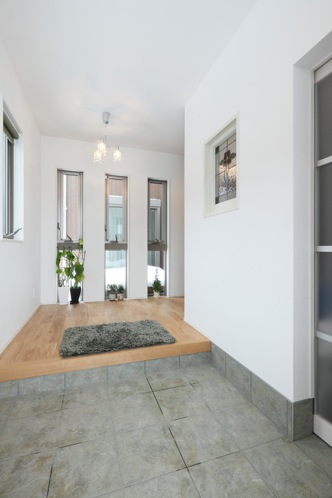 Contemporary entry hall in Other with white walls and grey floor.