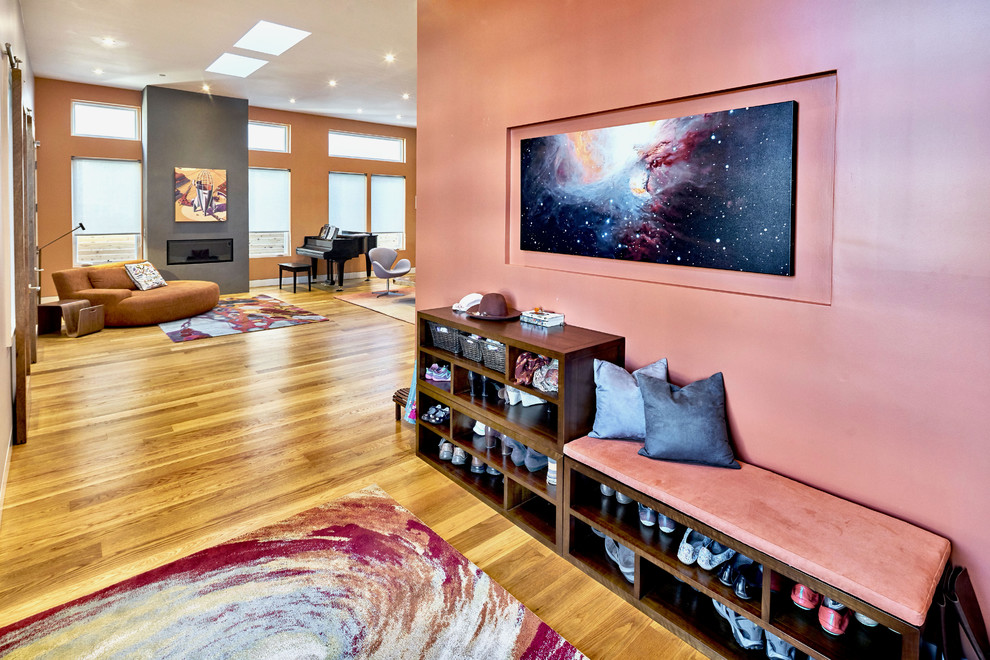 This is an example of a mid-sized contemporary foyer in San Francisco with pink walls and light hardwood floors.