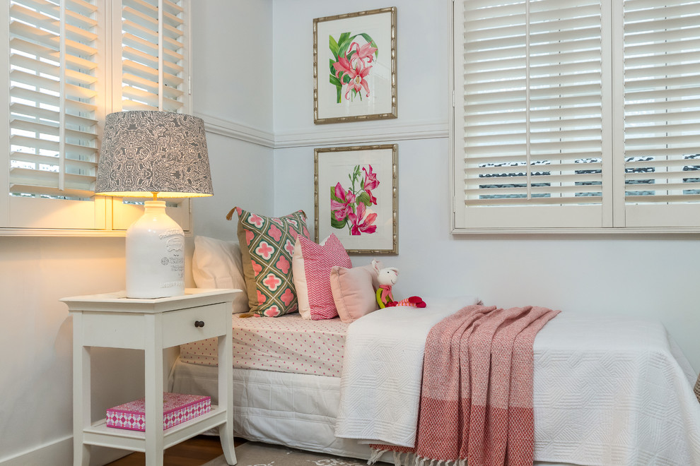 This is an example of a beach style kids' bedroom for kids 4-10 years old and girls in Brisbane with white walls, medium hardwood floors and brown floor.