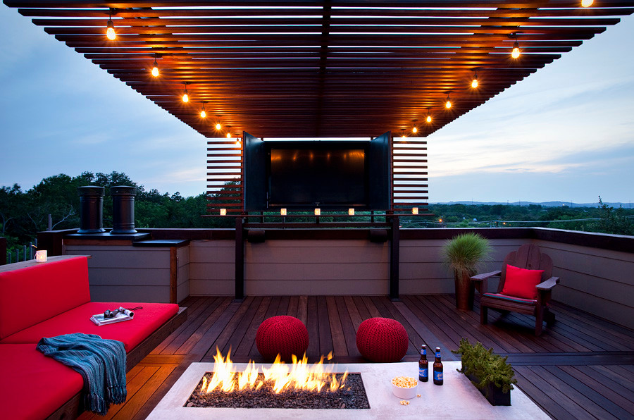 Inspiration for a mid-sized modern patio in Austin with a water feature, decking and a pergola.