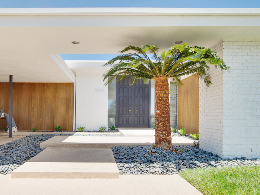フェニックスにある高級な中くらいなミッドセンチュリースタイルのおしゃれな家の外観 (塗装レンガ) の写真
