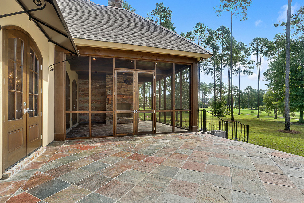 Traditional backyard screened-in verandah in New Orleans with tile and a roof extension.