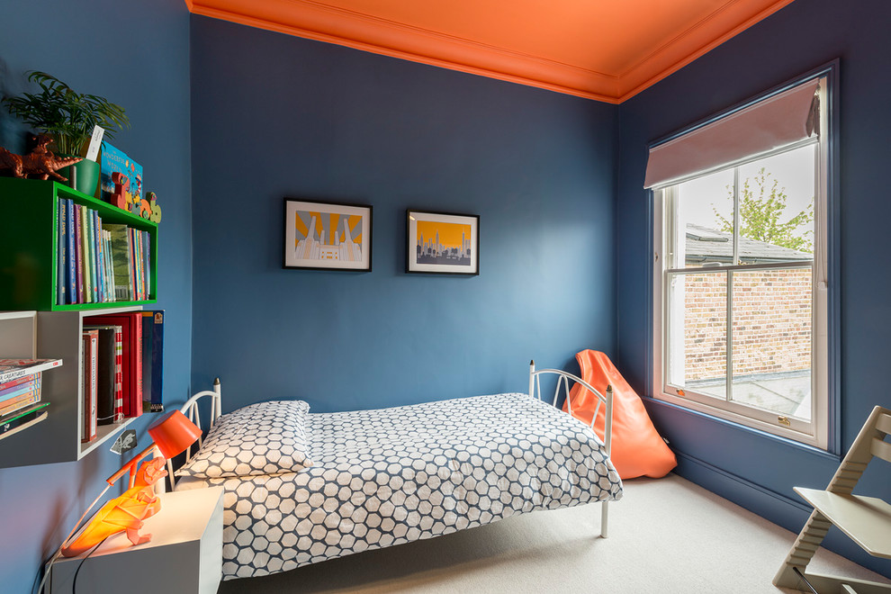 Design ideas for a mid-sized contemporary kids' bedroom for boys and kids 4-10 years old in London with blue walls, carpet and beige floor.
