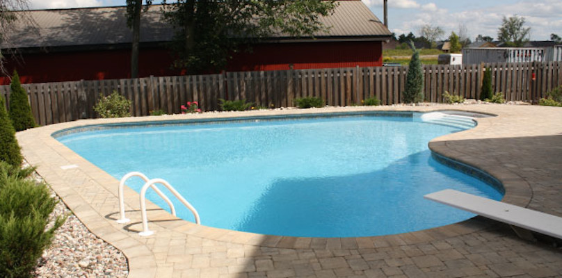 Mid-sized backyard concrete paver and freeform pool fountain photo