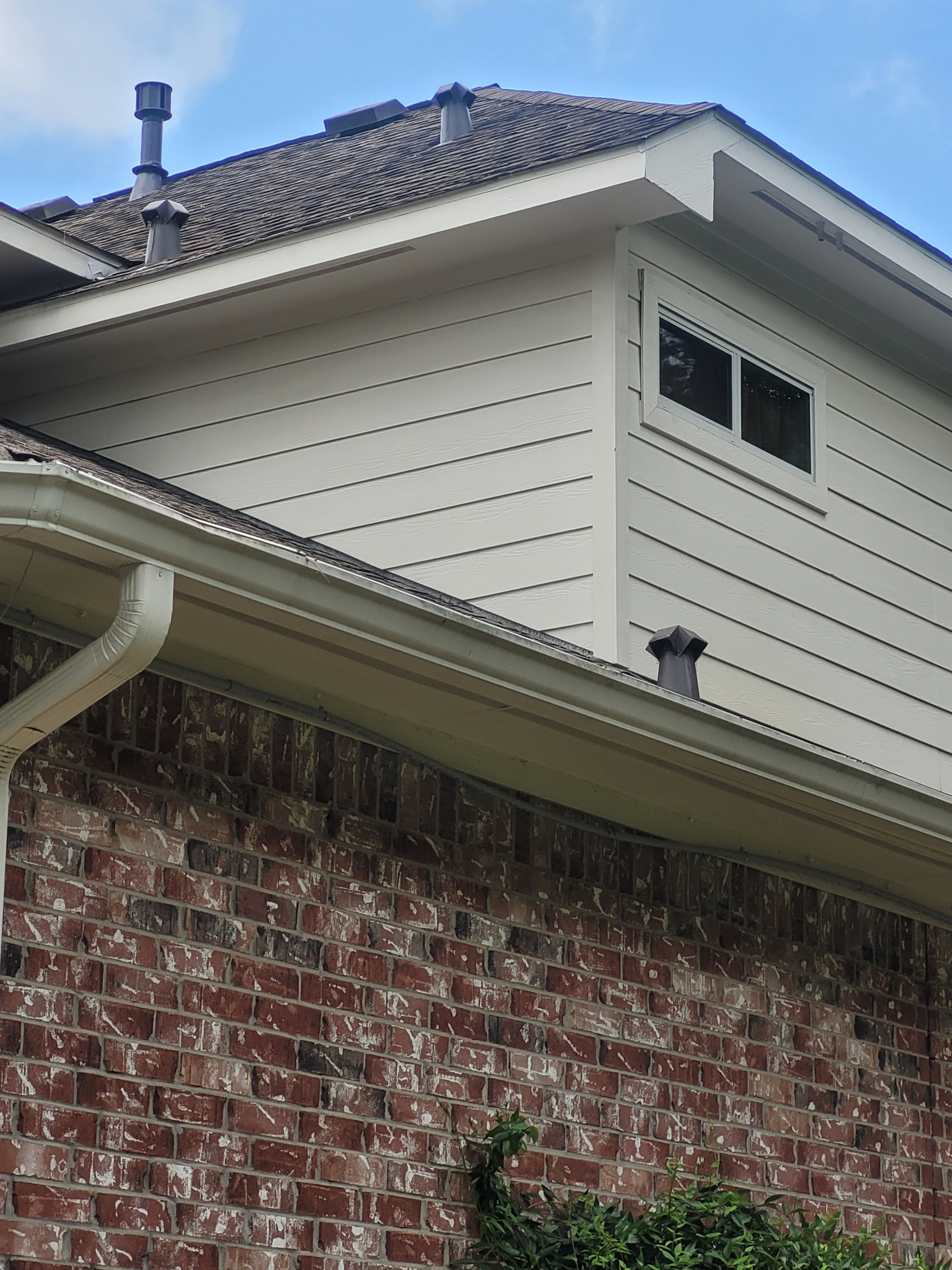 This project started with some non-Hardie fiber-cement siding planks delaminating above the roof lines. This was caused by the builder resting the siding on the roof, we cut all the siding on the hou