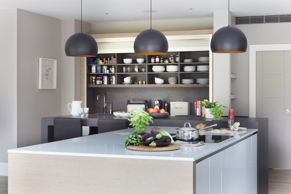 Inspiration for an expansive contemporary open plan kitchen in Surrey with an integrated sink, flat-panel cabinets, grey cabinets, quartzite benchtops, panelled appliances, porcelain floors, with island, grey floor and white benchtop.