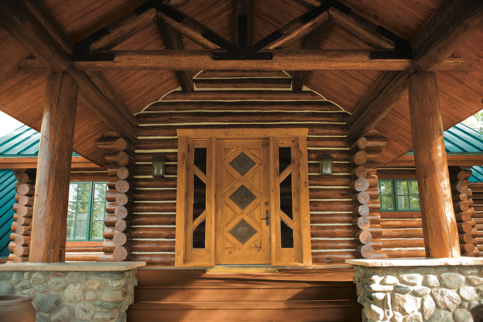 Large mountain style brown two-story wood gable roof photo with a metal roof