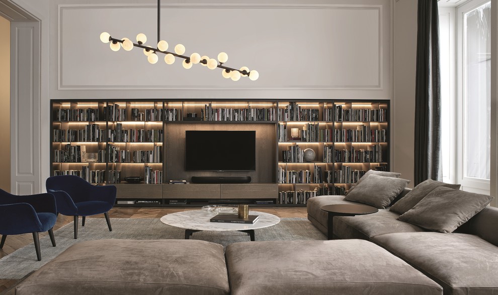 Inspiration for a transitional family room in London with a library, white walls, medium hardwood floors, a wall-mounted tv and brown floor.