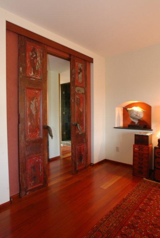 Inspiration for a large asian hallway in San Diego with red walls, dark hardwood floors and brown floor.