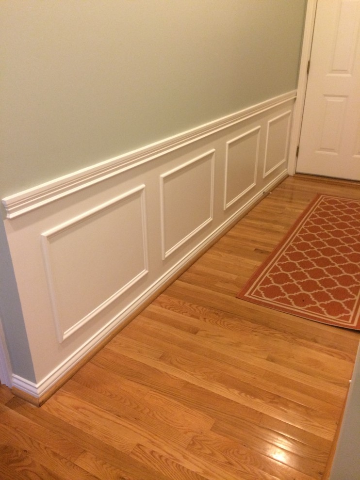 Photo of a mid-sized traditional hallway in Louisville with green walls and light hardwood floors.