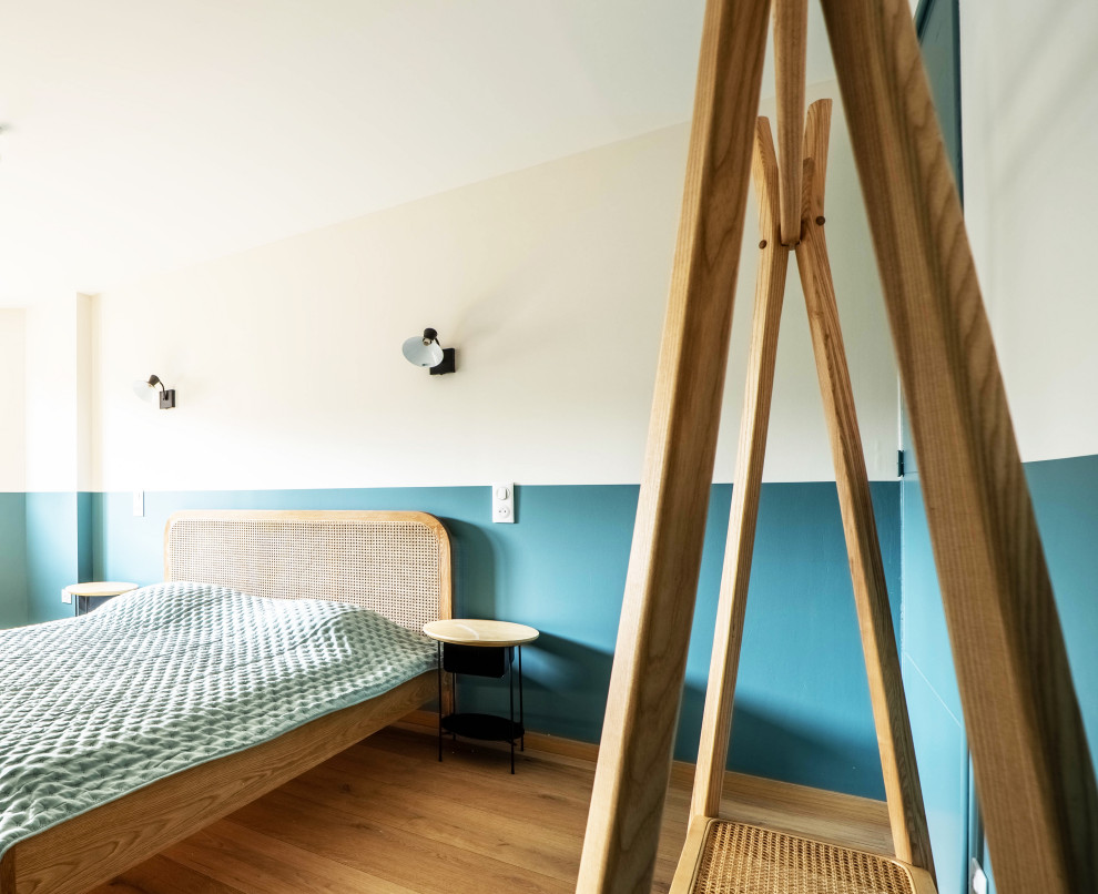 Réalisation d'une chambre d'enfant design de taille moyenne avec un mur bleu et parquet clair.