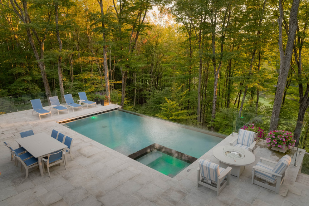 Inspiration pour un piscine avec aménagement paysager arrière traditionnel de taille moyenne et rectangle avec des pavés en pierre naturelle.