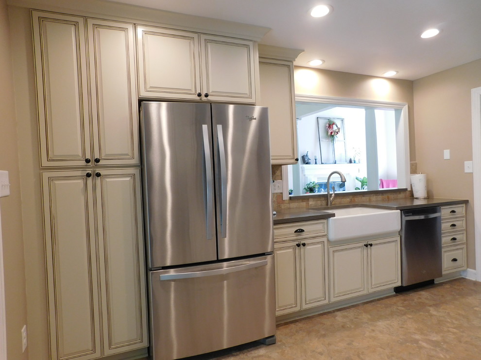 Inspiration for a mid-sized transitional galley vinyl floor enclosed kitchen remodel with a farmhouse sink, raised-panel cabinets, beige cabinets, solid surface countertops, multicolored backsplash, stone tile backsplash, stainless steel appliances and no island