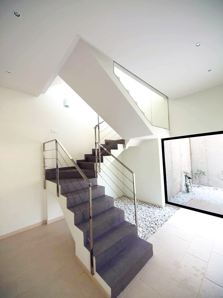 This is an example of a mid-sized contemporary tile l-shaped staircase in Other with tile risers.