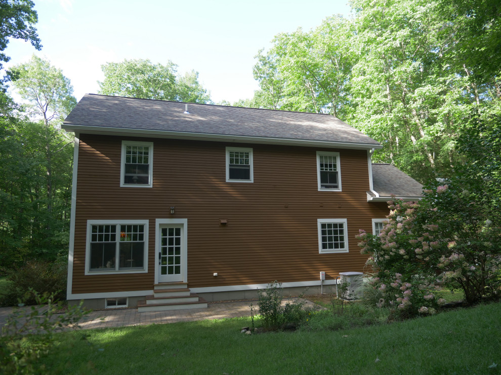 Ejemplo de fachada gris tradicional de dos plantas con tejado a dos aguas y tejado de teja de madera