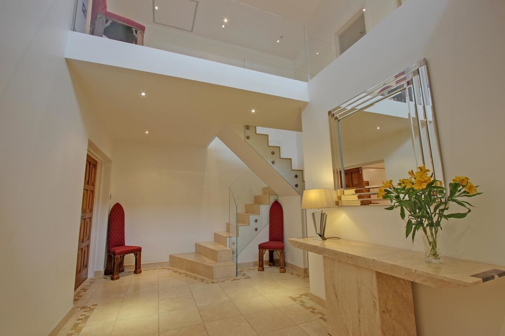 Photo of a large contemporary hallway in London with white walls and travertine floors.
