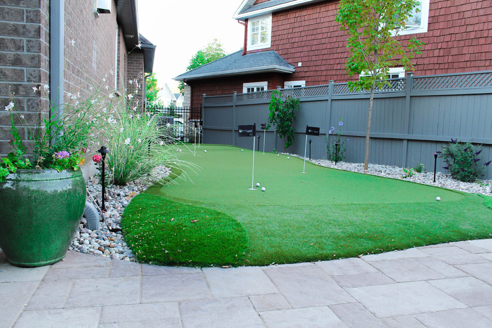 Photo of a mid-sized eclectic side yard outdoor sport court for summer in Ottawa with natural stone pavers.