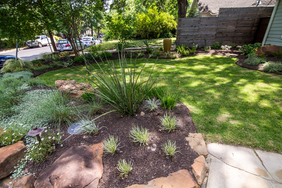 This is an example of a mid-sized modern front yard xeriscape in Austin.