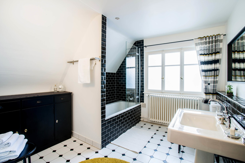 Design ideas for a large transitional master bathroom in Strasbourg with louvered cabinets, black cabinets, an undermount tub, a shower/bathtub combo, a one-piece toilet, black tile, porcelain tile, white walls, ceramic floors, a trough sink, tile benchtops, multi-coloured floor, an open shower and white benchtops.
