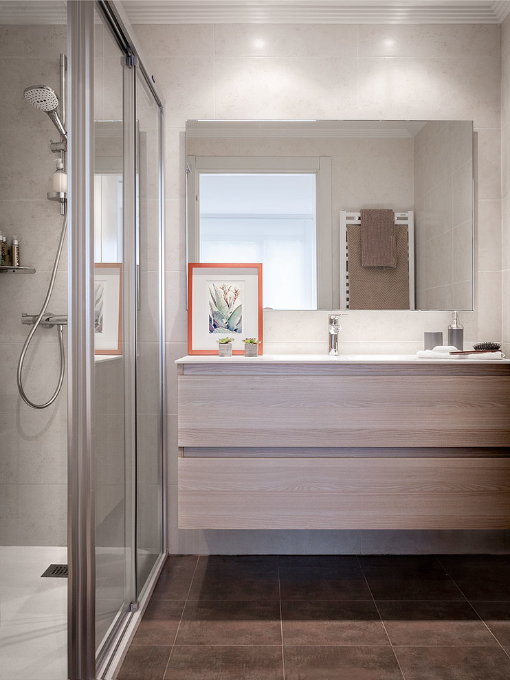 Photo of a small contemporary 3/4 bathroom in Bilbao with flat-panel cabinets, light wood cabinets, a freestanding tub, a curbless shower, a wall-mount toilet, brown tile, ceramic tile, a drop-in sink, engineered quartz benchtops and a sliding shower screen.