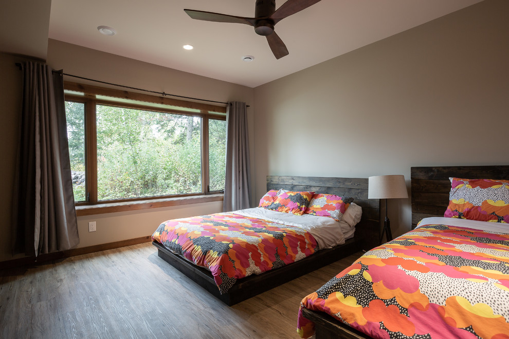 This is an example of a large beach style guest bedroom in Other with black walls, linoleum floors and brown floor.