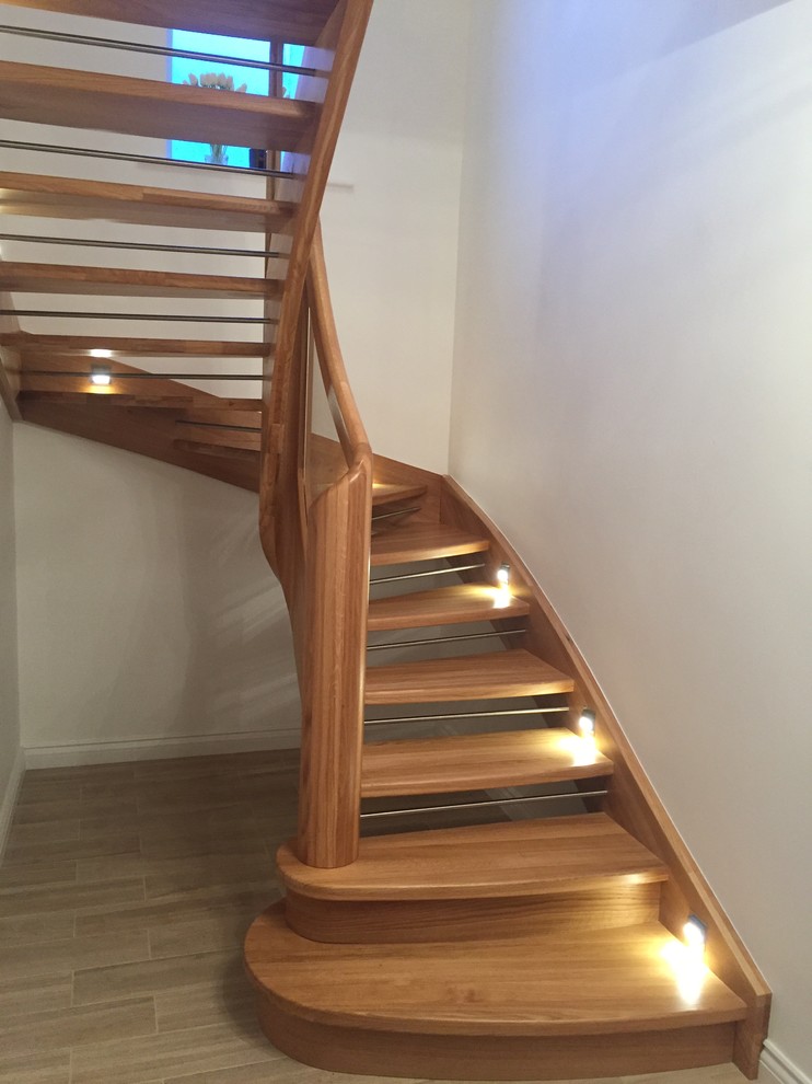 Small contemporary wood u-shaped staircase in Manchester with metal risers and glass railing.