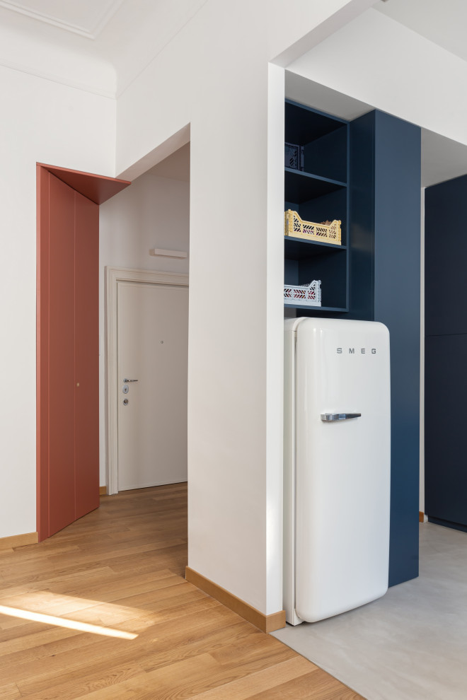 Medium sized contemporary l-shaped open plan kitchen in Milan with flat-panel cabinets, blue cabinets, concrete worktops, yellow splashback, concrete flooring, no island, grey floors and yellow worktops.