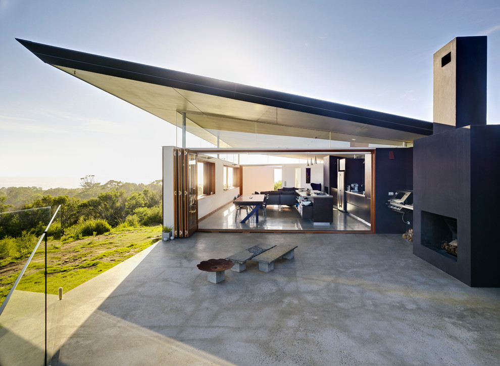 Photo of a mid-sized modern patio in Sydney with with fireplace.