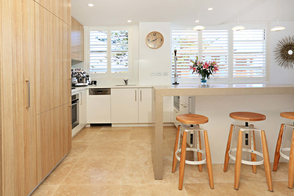 Design ideas for a small contemporary u-shaped eat-in kitchen in Sydney with flat-panel cabinets, white cabinets, solid surface benchtops, glass sheet splashback, white appliances, travertine floors and a peninsula.