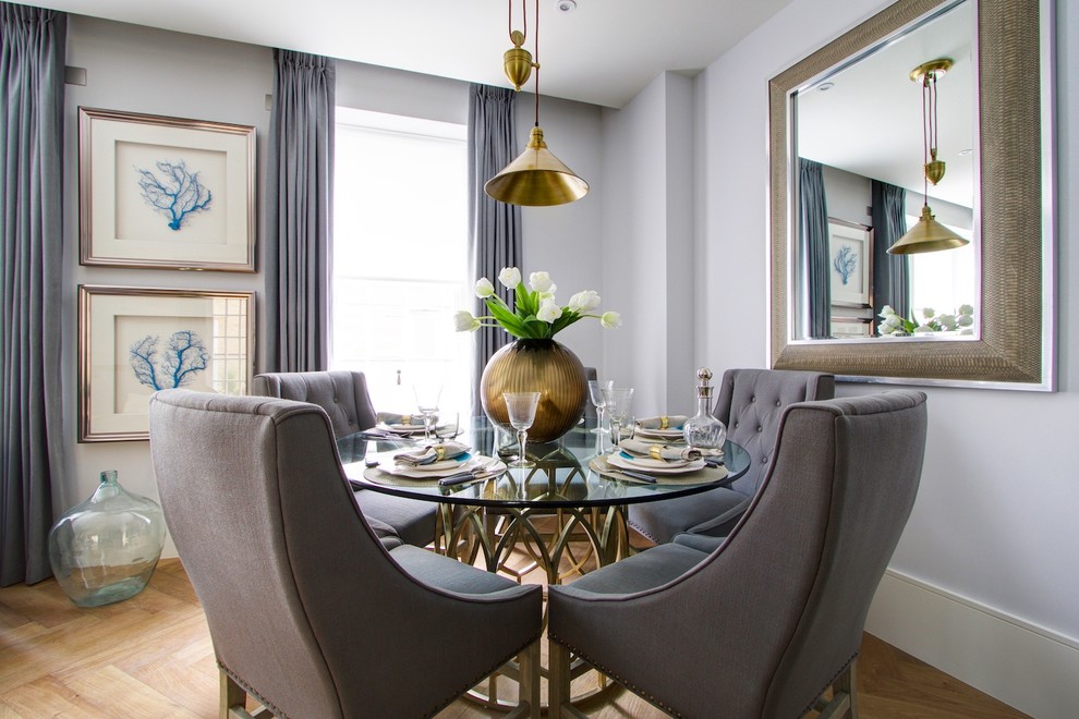Photo of a transitional dining room in London with grey walls and light hardwood floors.