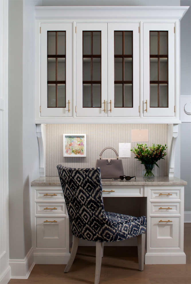 Diseño de despacho contemporáneo con paredes grises, suelo de madera en tonos medios, escritorio independiente y suelo marrón