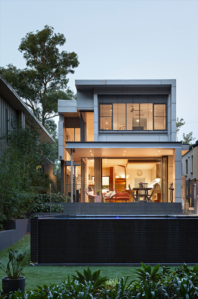 Design ideas for a contemporary two-storey white exterior in Brisbane with mixed siding and a flat roof.