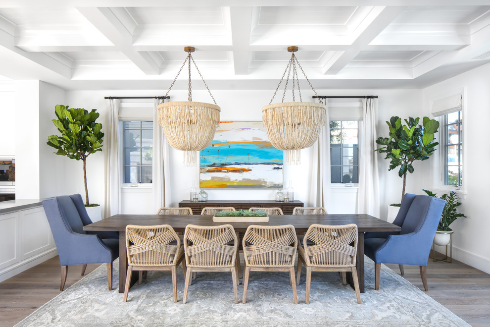 Inspiration for a mid-sized beach style open plan dining in Orange County with white walls, medium hardwood floors, no fireplace and grey floor.